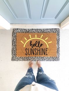 a person standing in front of a door mat that says hello sunshine on the bottom