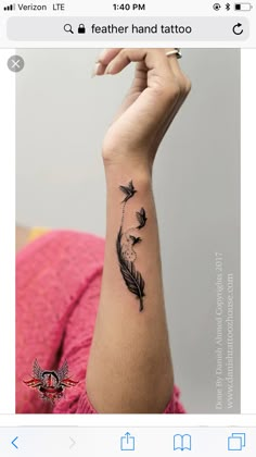 a woman's arm with a black feather tattoo on the left side of her wrist