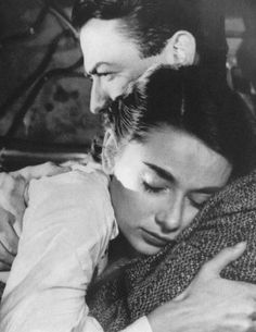 an old black and white photo of a man hugging a woman's head with her eyes closed