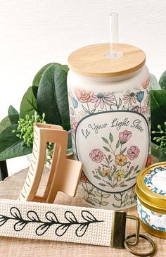 an assortment of items on a table including a jar, candle and letter openers