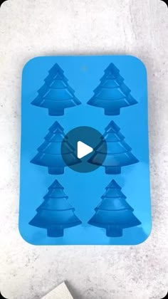 a cookie sheet with christmas trees on it and a video play button in the middle