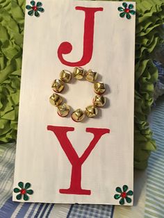 a sign that says joy with bells on it