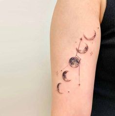 a woman's arm with three phases of the moon and stars tattoo on it