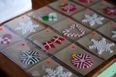 several pieces of fabric with christmas decorations on them sitting on top of a wooden table