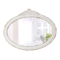 a white oval mirror sitting next to a window