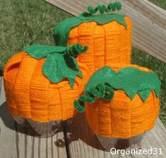 two orange pumpkins sitting on top of a wooden table next to eachother