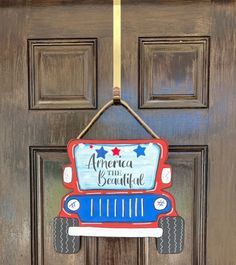 a door hanger that says america is beautiful on it's front door, with an american truck painted in red, white and blue