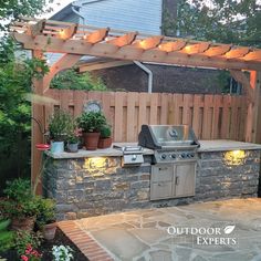 an outdoor kitchen is lit up with lights