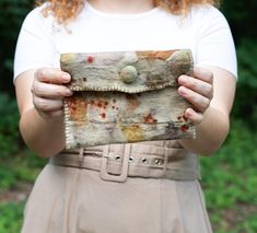 a woman holding an old purse in her hands