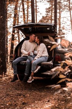 two people sitting in the trunk of a car