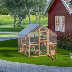 an image of a chicken coop in the grass next to a red house and chickens