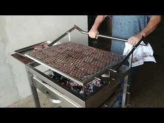 a man is grilling hot dogs on an outdoor grill