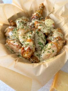 chicken wings covered in gravy and garnished with parmesan cheese