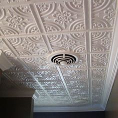 the ceiling in this room is decorated with intricate white paint and decorative designs on it