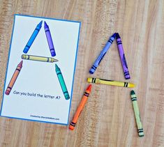 two crayons are next to a card with the letter a on it and some crayons