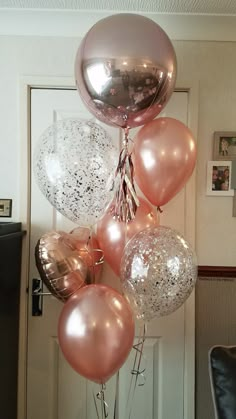 a bunch of balloons that are hanging from the ceiling in front of a door,