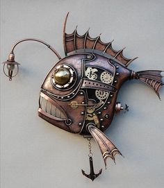 a metal fish clock hanging on the side of a wall next to a light fixture