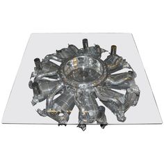 a glass table topped with lots of metal objects on wheels and feet in the shape of a sunburst