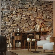 a living room with a stone wall and wooden furniture in front of the bookshelf