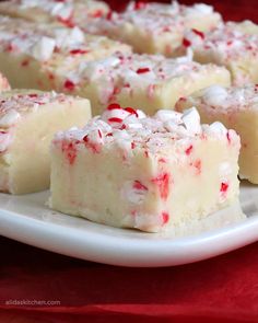 white chocolate peppermint fudge on a plate with red and white candy canes