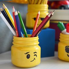 a yellow jar filled with pencils and other colored pencils sitting on top of a table