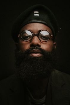 a man with glasses and a beard wearing a hat