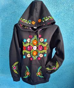 This colorful sweatshirt is perfect to keep warm, comfortable, and stylish during the cold winter months. They have hand embroidered details on both sleeves, front center, and on the hoodie. This sweatshirt is hand embroidered by Mexican Artisans and each can take up to a week for one person to finish!  Each sweater is 50% cotton/50% polyester.  Please choose a size in the drop down menu. You will receive a sweatshirt with the same pattern as the picture, however, the colors may differ as they a Hand Embroidered Sweatshirt, Colorful Sweatshirt, Floral Sweatshirt, Embroidery Sweater, Embroidered Details, Hoodie Pullover, Embroidered Sweatshirt, Embroidered Hoodie, Embroidered Sweatshirts