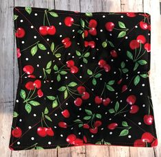 a black and red cloth with cherries on it