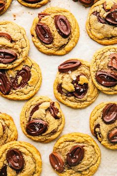 cookies with chocolate chips and pecans on a sheet of parchment paper, ready to be eaten