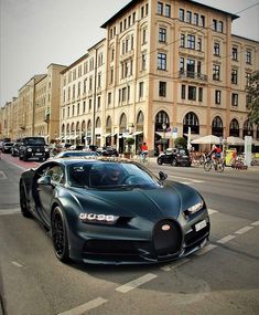 a bugatti car is driving down the street in front of some tall buildings