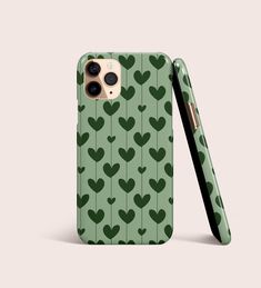 a green phone case with hearts on it and a black pen sticking out of the back