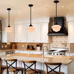 a kitchen with white cabinets and wooden stools next to an island in the middle