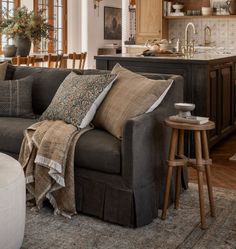 a living room filled with furniture next to a kitchen