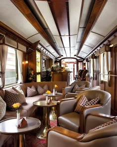 the inside of a train car with couches, tables and chairs on each side