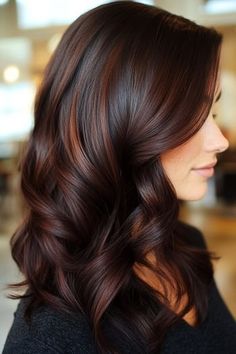 Save this pin for the best fall hair color ideas. A mahogany base shade is brightened with auburn highlights to add warmth to the look. The loose waves showcase the color variation. Juda Design, Brown Bayalage Hair, Mahogany Highlights, Brown Auburn Hair, Dark Fall Hair Colors, Hair Color Mahogany, Mahogany Hair, Highlights For Dark Brown Hair, Dark Fall Hair