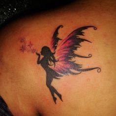 a woman with a tattoo on her back holding a sparkler in her right hand