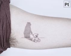 a bear and cub tattoo on the left arm