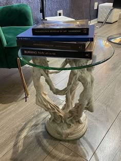 a glass table topped with books on top of a wooden floor