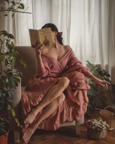 a woman sitting in a chair reading a book