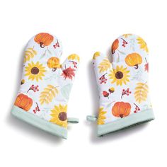 two oven mitts with sunflowers and leaves on them, one is white