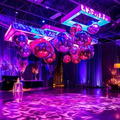 a large room filled with lots of shiny balloons and disco balls hanging from the ceiling