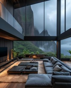 a living room with large windows and a mountain view in the backgrounnd