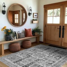 a room with a rug, mirror and wooden doors