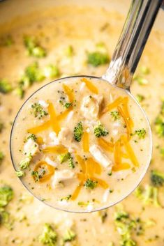 chicken broccoli cheese soup in a glass bowl with a spoon on the side