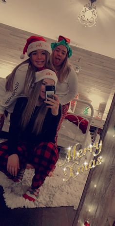 two women are taking a selfie in their christmas pajamas and santa's hats