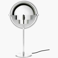 a round mirror on a metal stand with a black cord plugged in to it