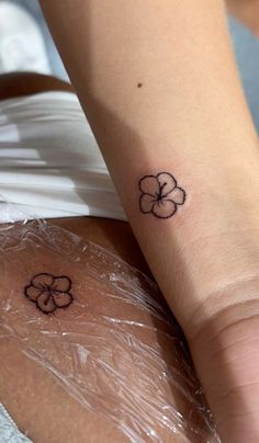 a woman's arm with two clover tattoos on it