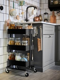 a kitchen with a blue cart filled with lots of jars and containers on top of it