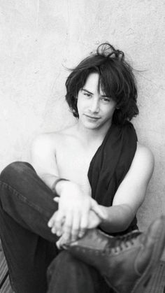 a black and white photo of a shirtless woman sitting on a wooden bench with her hands crossed