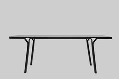 a rectangular table with black legs on a grey background